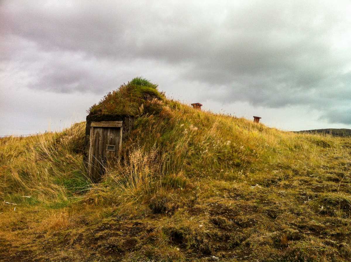 An old-fashioned turf building, barely visible
